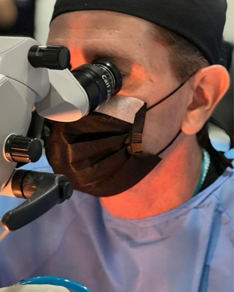 Médico trabalha com microscópio cirúrgico